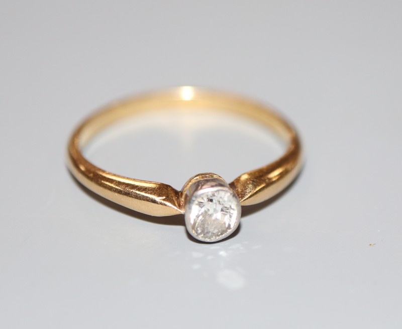 An 18ct and millegrain set solitaire diamond ring, size N, gross 2.5 grams.